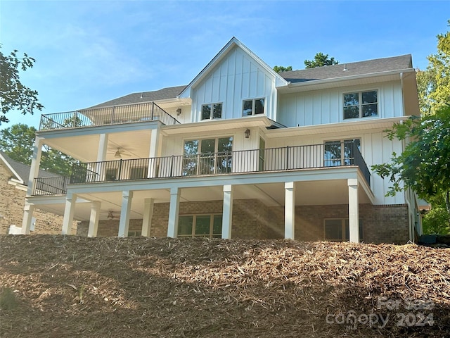 rear view of property featuring ceiling fan and a balcony