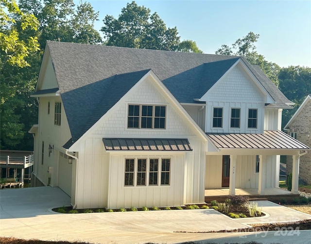 modern farmhouse style home with a porch, a standing seam roof, and board and batten siding