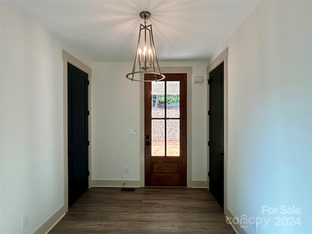 entryway featuring dark wood-style flooring, visible vents, a notable chandelier, and baseboards