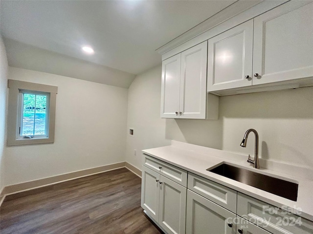 interior space with lofted ceiling, a sink, baseboards, light countertops, and dark wood finished floors