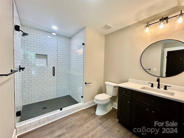 full bathroom with toilet, wood finished floors, vanity, visible vents, and a shower stall