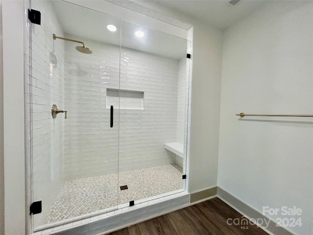 full bath featuring baseboards, wood finished floors, and a shower stall