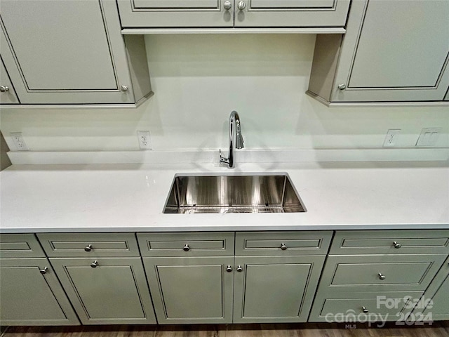 kitchen featuring gray cabinets, light countertops, and a sink