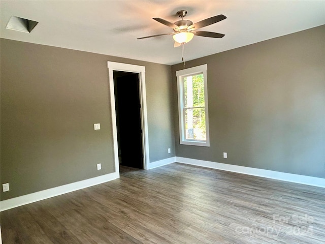 empty room with dark wood-style floors, baseboards, and a ceiling fan