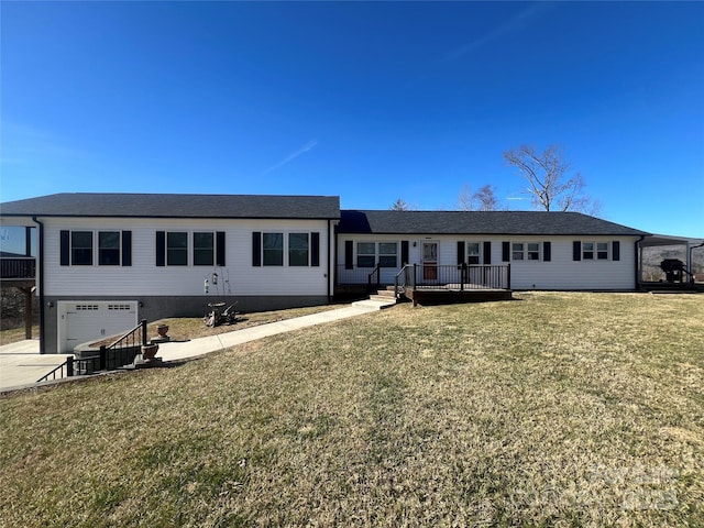 ranch-style home featuring concrete driveway, an attached garage, a deck, and a front lawn