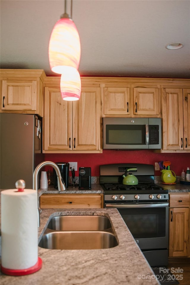 kitchen with light brown cabinets, stainless steel appliances, and a sink