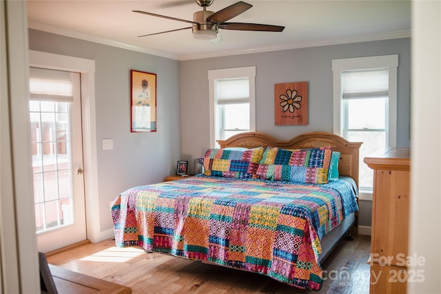 bedroom with multiple windows, crown molding, and wood finished floors