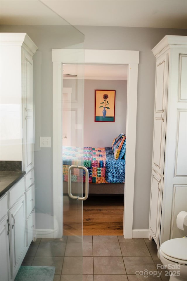 bathroom featuring baseboards, toilet, ensuite bath, tile patterned floors, and vanity