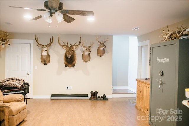 interior space featuring light wood-style floors, baseboards, and a ceiling fan