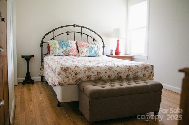 bedroom featuring baseboards and wood finished floors