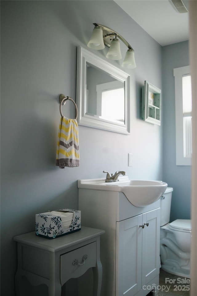 bathroom featuring visible vents, vanity, and toilet