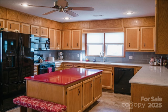 kitchen with black appliances, a sink, visible vents, and decorative backsplash