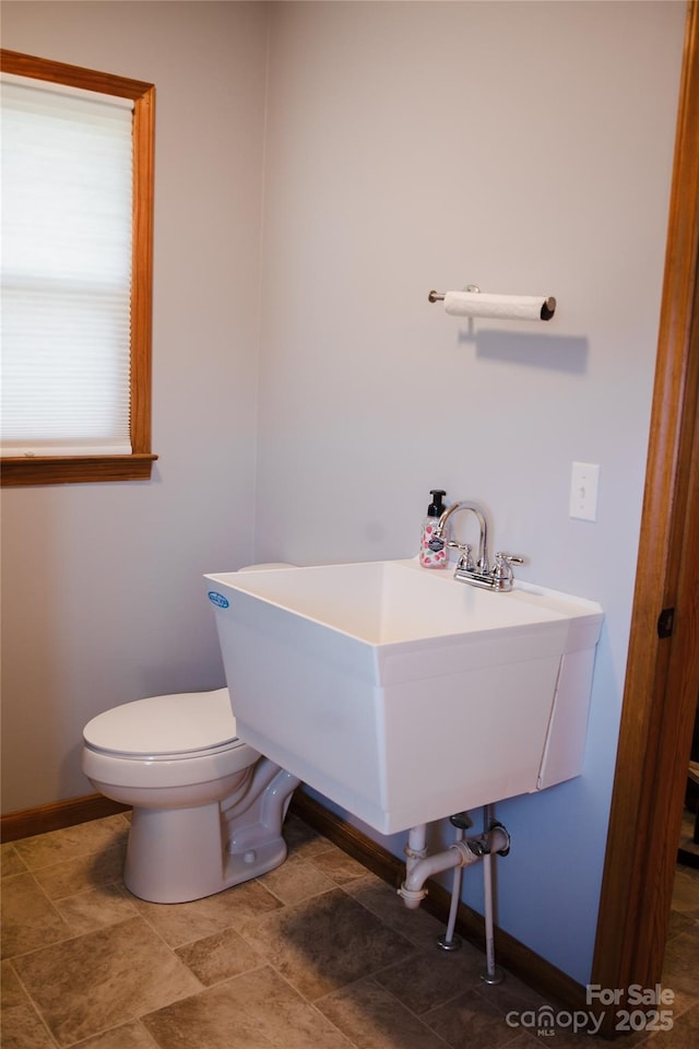 bathroom with baseboards and toilet