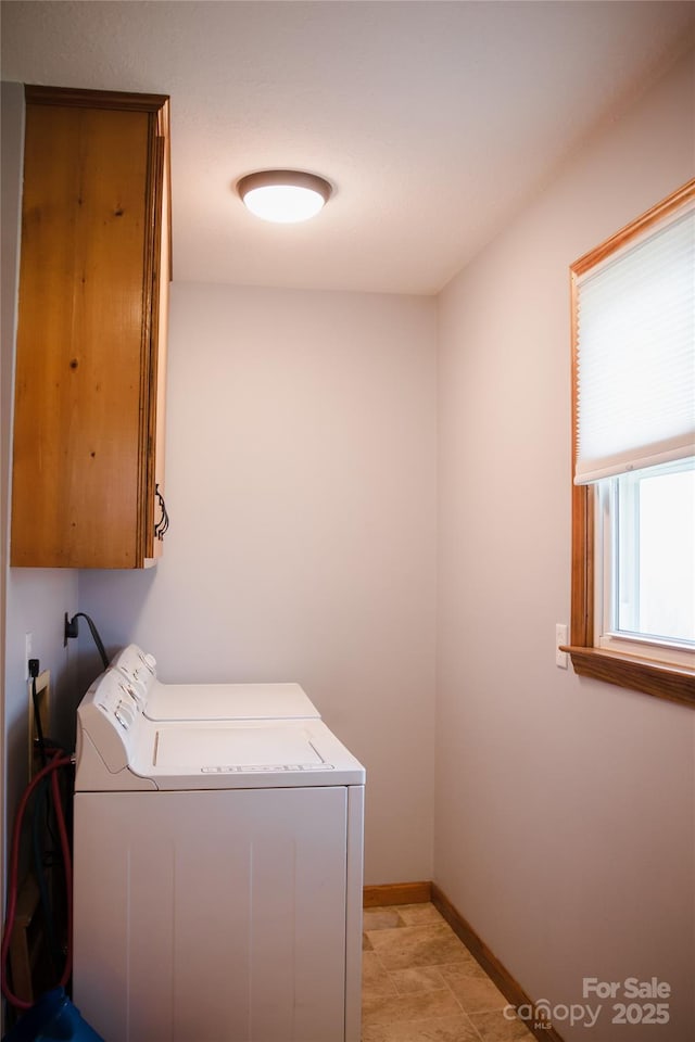 washroom with washing machine and clothes dryer, cabinet space, and baseboards