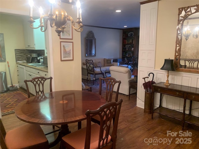 dining space with a chandelier, dark hardwood / wood-style floors, and sink