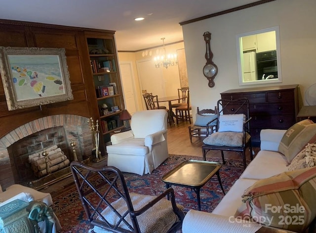 living room with a fireplace, an inviting chandelier, and crown molding