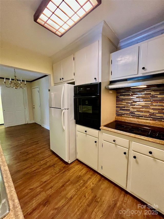 kitchen with backsplash, a notable chandelier, black appliances, light wood-type flooring, and white cabinets