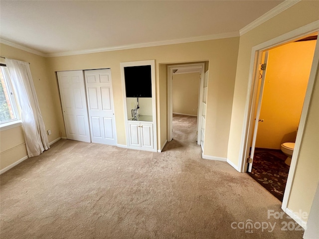 unfurnished bedroom featuring light colored carpet, connected bathroom, a closet, and crown molding