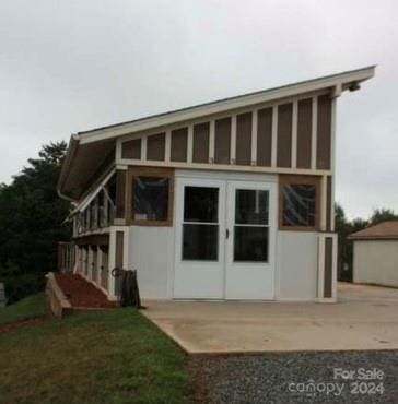 back of property with french doors and an outbuilding