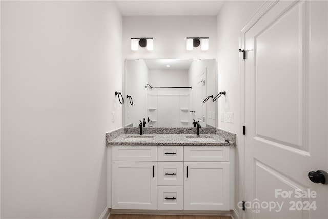 bathroom featuring walk in shower and vanity