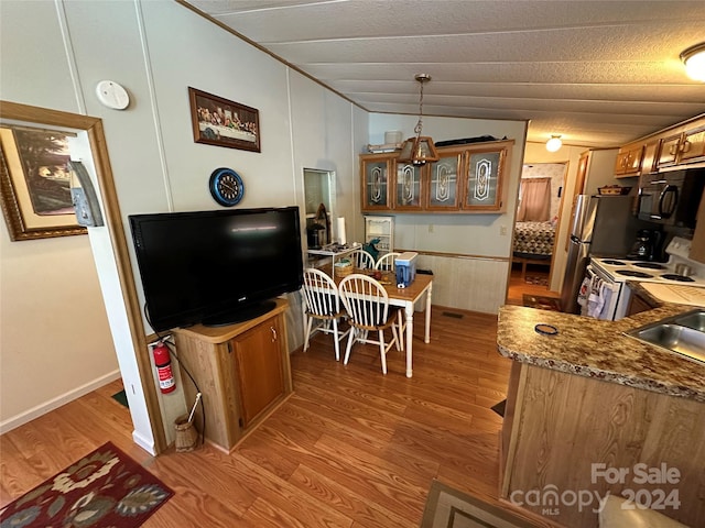 kitchen with light hardwood / wood-style flooring, white electric stove, kitchen peninsula, a textured ceiling, and lofted ceiling