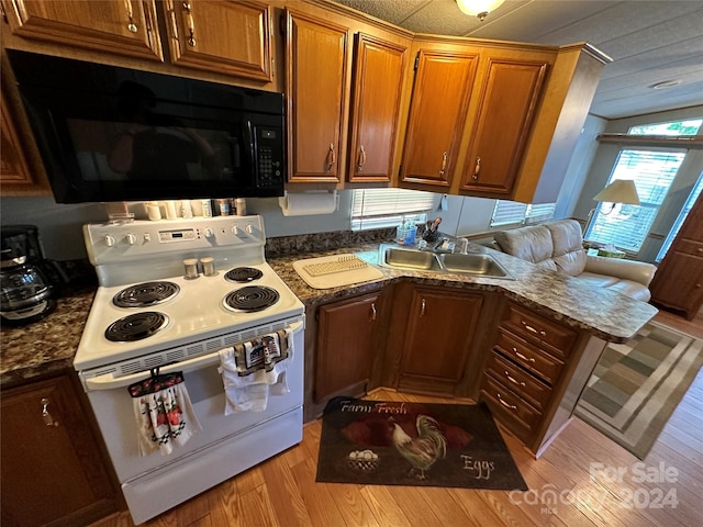 kitchen with vaulted ceiling, light hardwood / wood-style floors, white electric stove, and sink