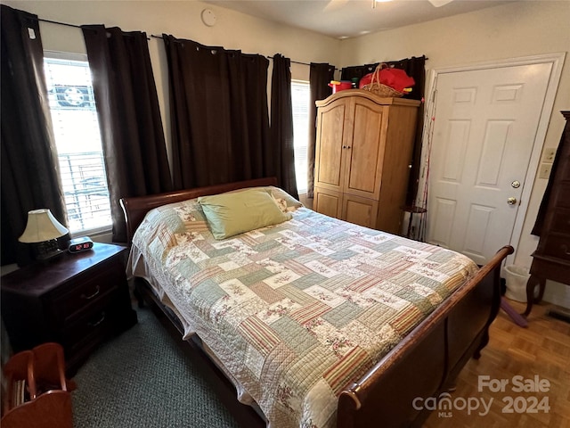 bedroom featuring ceiling fan, a closet, and dark parquet floors