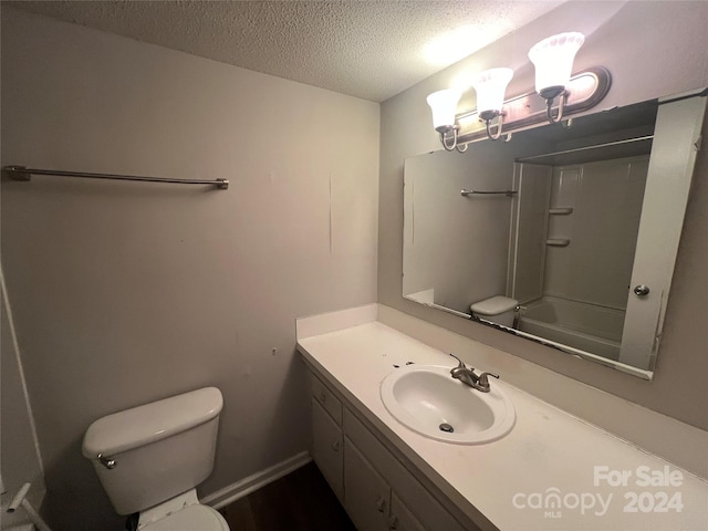 full bathroom with vanity, toilet, a textured ceiling, and shower / bathing tub combination