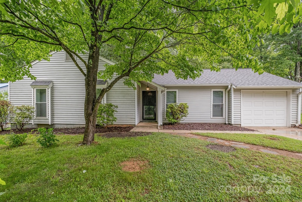 view of front of house with a garage and a front lawn