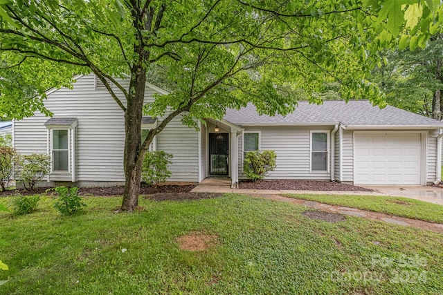 view of front of house with a garage and a front lawn