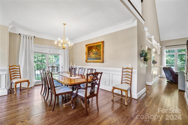 dining space featuring dark hardwood / wood-style floors, crown molding, and an inviting chandelier