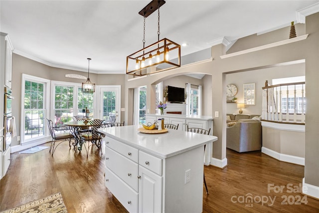 kitchen with pendant lighting, a center island, white cabinetry, dark hardwood / wood-style floors, and a breakfast bar