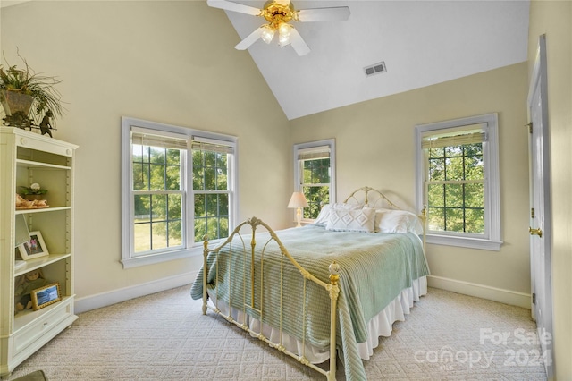 carpeted bedroom featuring ceiling fan, multiple windows, and high vaulted ceiling