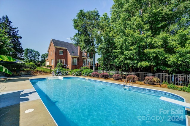 view of pool featuring a diving board