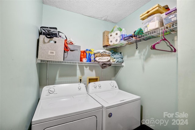 washroom with a textured ceiling and independent washer and dryer