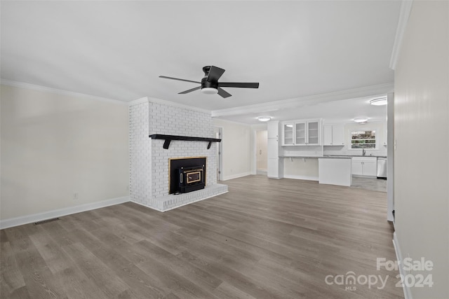 unfurnished living room featuring ceiling fan, crown molding, hardwood / wood-style flooring, and sink