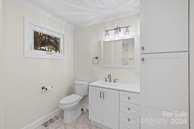 bathroom with toilet, vanity, and crown molding