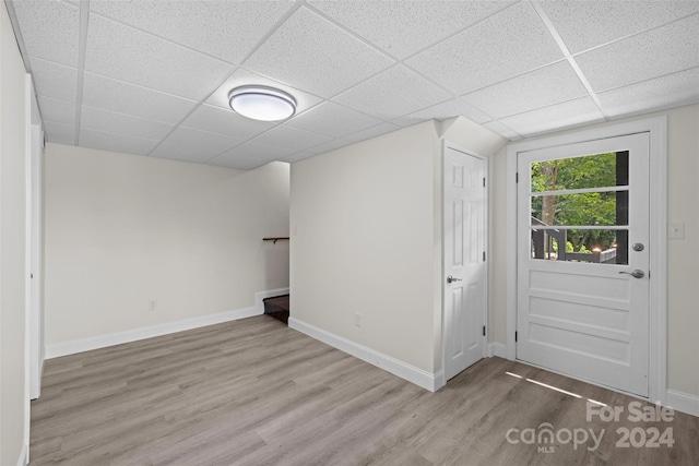 interior space featuring a paneled ceiling and light hardwood / wood-style flooring