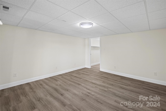 basement featuring hardwood / wood-style flooring and a drop ceiling