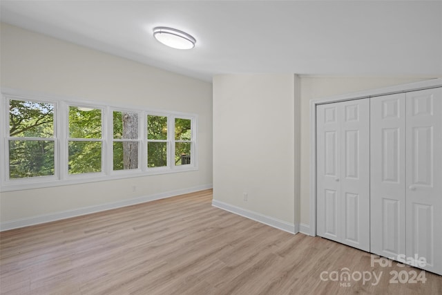 unfurnished bedroom with a closet and light hardwood / wood-style flooring