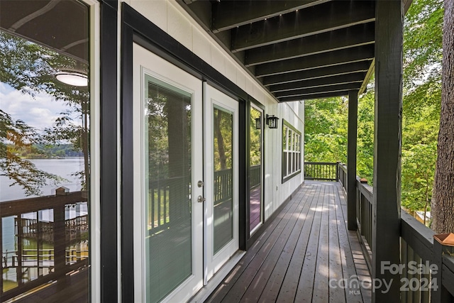 wooden deck featuring a water view and french doors