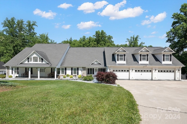 view of front of home featuring a porch, a garage, and a front yard