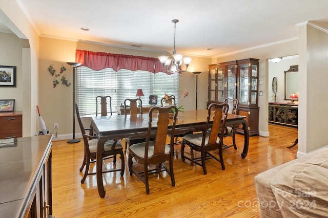 dining space featuring a chandelier, light hardwood / wood-style flooring, and ornamental molding