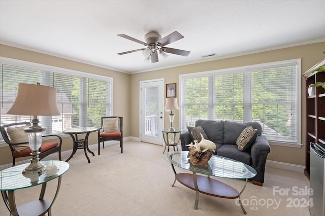 carpeted living room featuring ceiling fan and ornamental molding