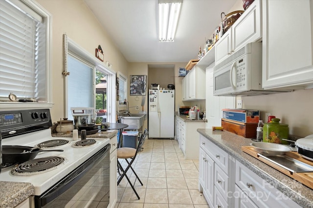 kitchen with white cabinets, white appliances, and light tile patterned floors