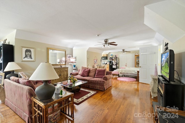 living room with ceiling fan and light hardwood / wood-style flooring