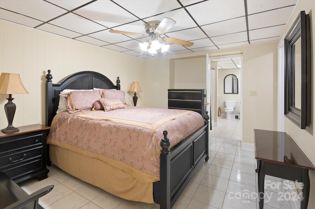 tiled bedroom featuring a paneled ceiling, ceiling fan, and ensuite bath