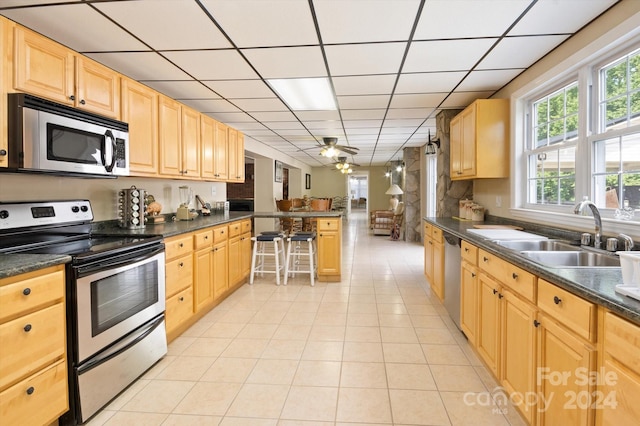 kitchen featuring light brown cabinets, sink, ceiling fan, appliances with stainless steel finishes, and light tile patterned flooring