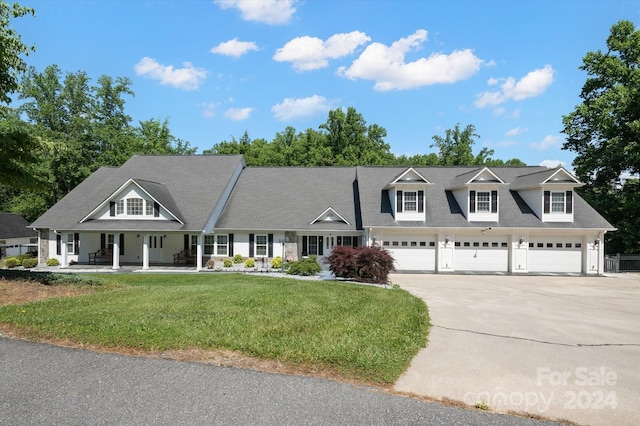 view of front facade featuring covered porch, a garage, and a front yard