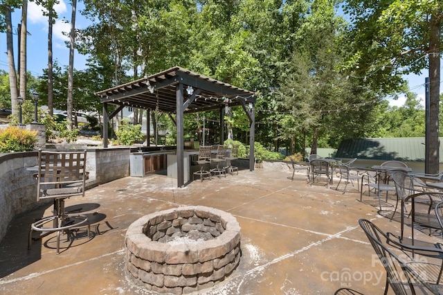 view of patio / terrace featuring an outdoor bar, area for grilling, and a fire pit